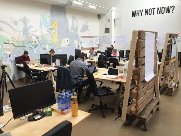 Startup Bootcamp location with people working in a well-used open office space
